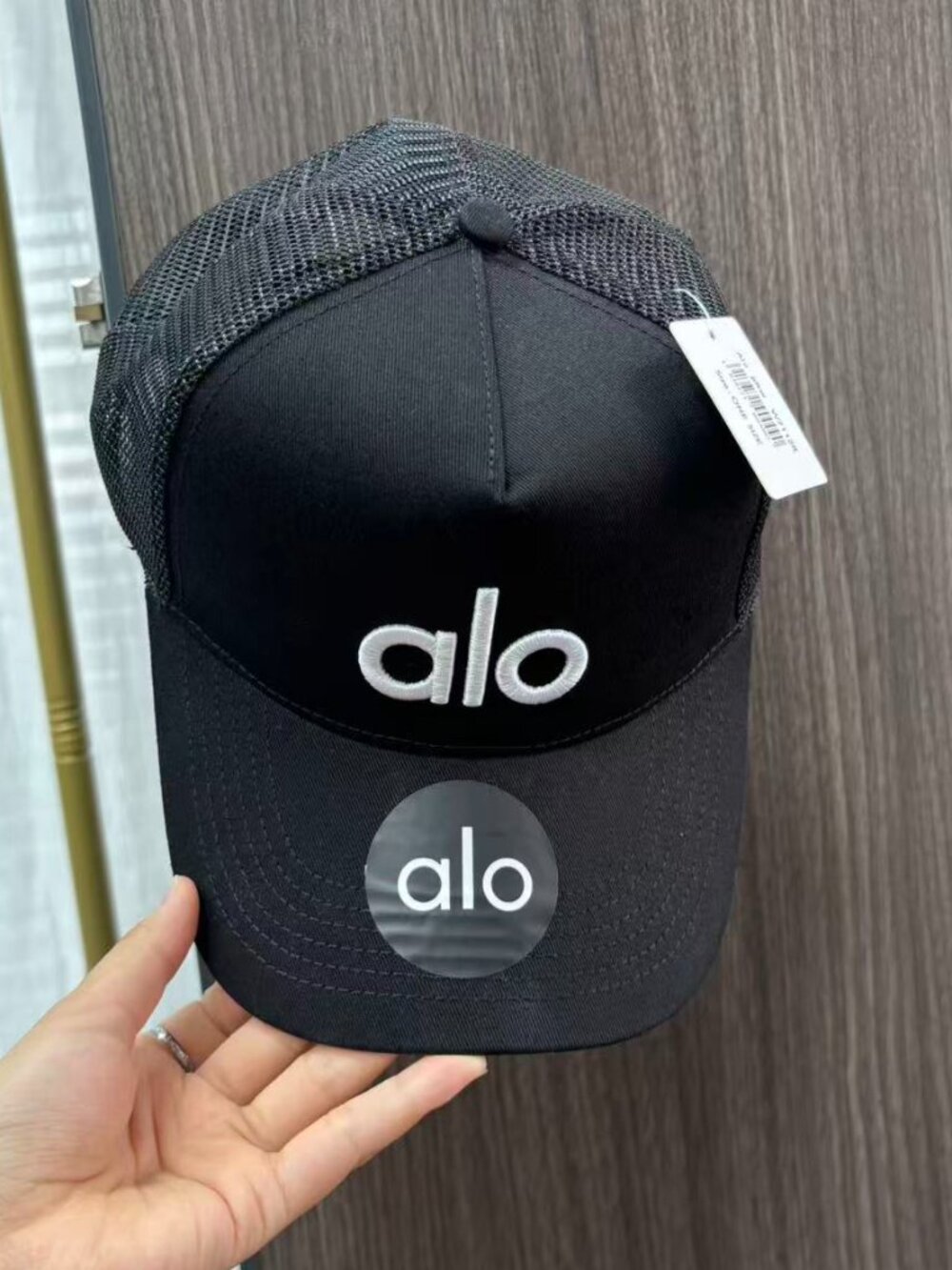 Alo Yoga black mesh baseball cap with white logo, street style.